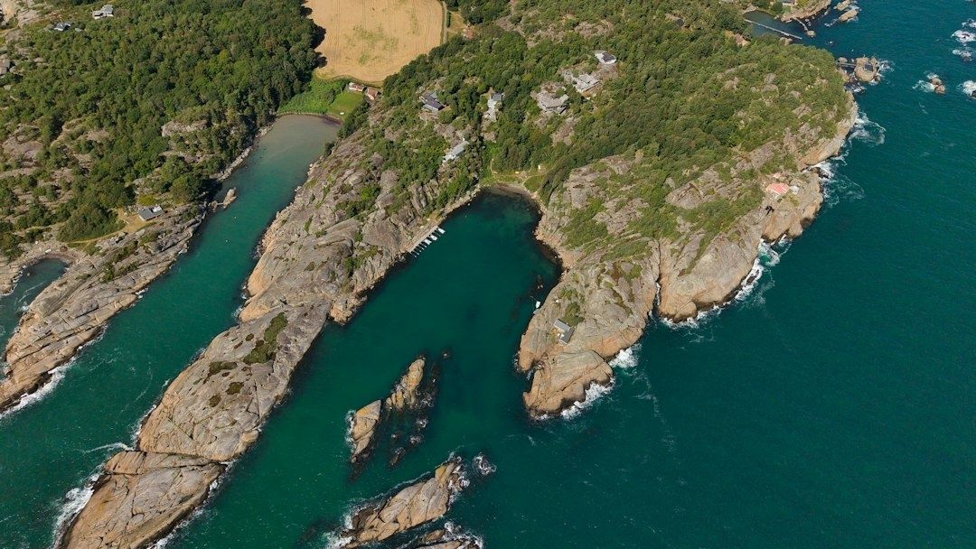 Flyfoto av skjærgård med lune viker, svaberg, brygger og holmer